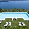 Pool mit Sonnenliegen der Villa Falcone mit Blick auf den Lago Maggiore
