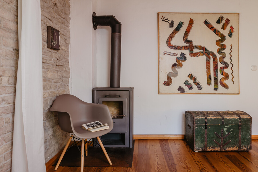 Wohnzimmer mit Ofen und Vitra Stuhl im Ferienhaus in den Marken