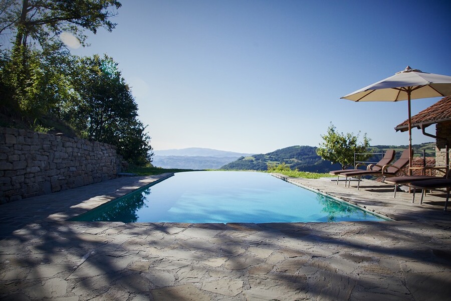 Schwimmbad mit Sonnenschirm der Villa dell Orso im Piemont