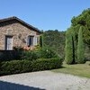Eingangsbereich der Ferienvilla Compignano Barn mit Zypressen, Obstbäumen und Ginster